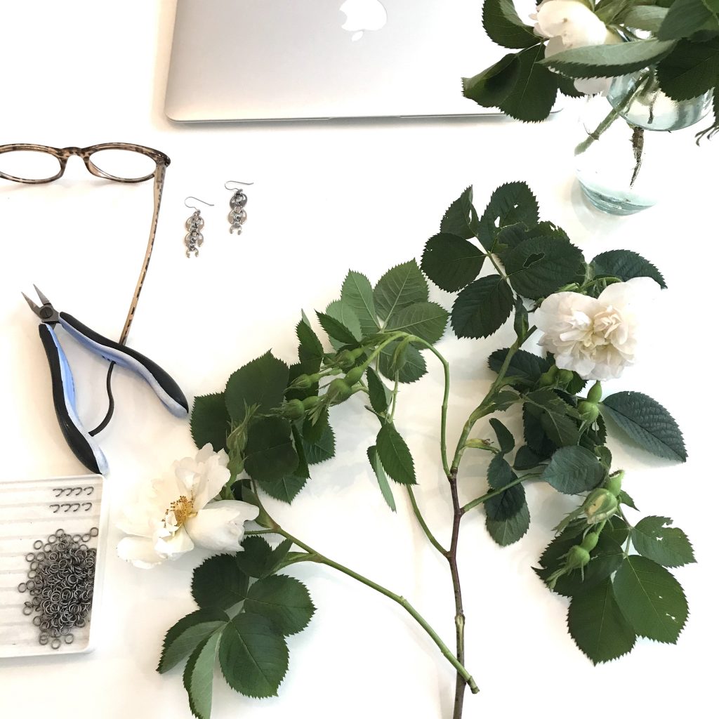 Alba roses and a sneak peek into Wraptillion's studio: reading glasses, laptop, pliers, titanium rings, and the Long Fuchsia Earrings.