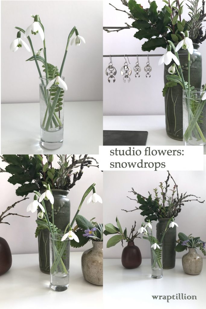 a collage of 4 photos, featuring cut snowdrops in a small glass vase with a fern frond, shown in front of other small winter leaf, branch, and flower arrangements and Wraptillion's Hops Earrings and Short Fuchsia Earrings. Text on image reads "studio flowers: snowdrops" and "wraptillion."