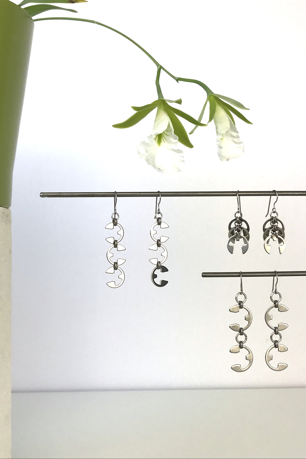 Wraptillion's Vine Earrings, Fir Cones Earrings, and Tendril Earrings with blooming orchid Encyclia mariae.