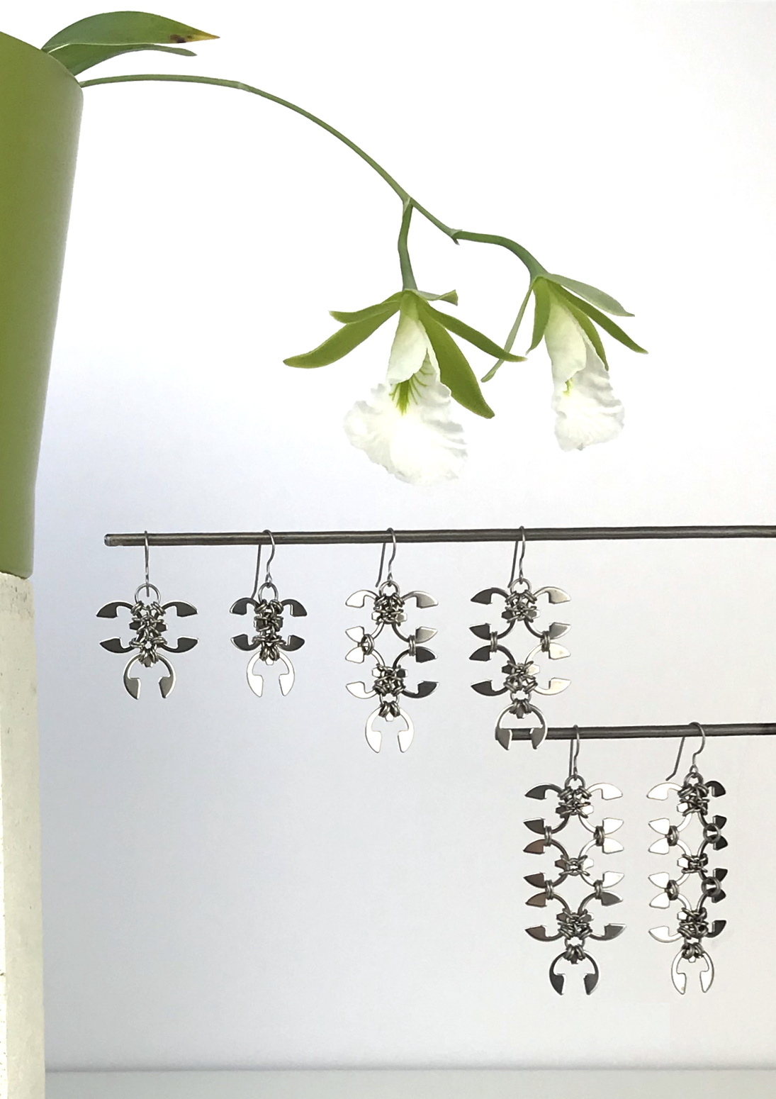 Wraptillion's Ivy Earrings, Short Wisteria Earrings, and Long Wisteria Earrings with blooming orchid Encyclia mariae.